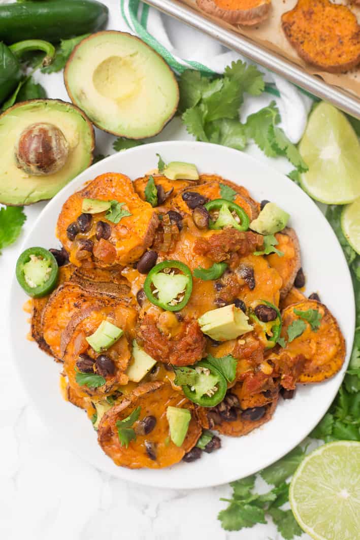 Loaded sweet potato nachos that are even better than traditional nachos! Healthy nachos with sweet potato, avocado, black beans, and melty cheese- what's not to love?!