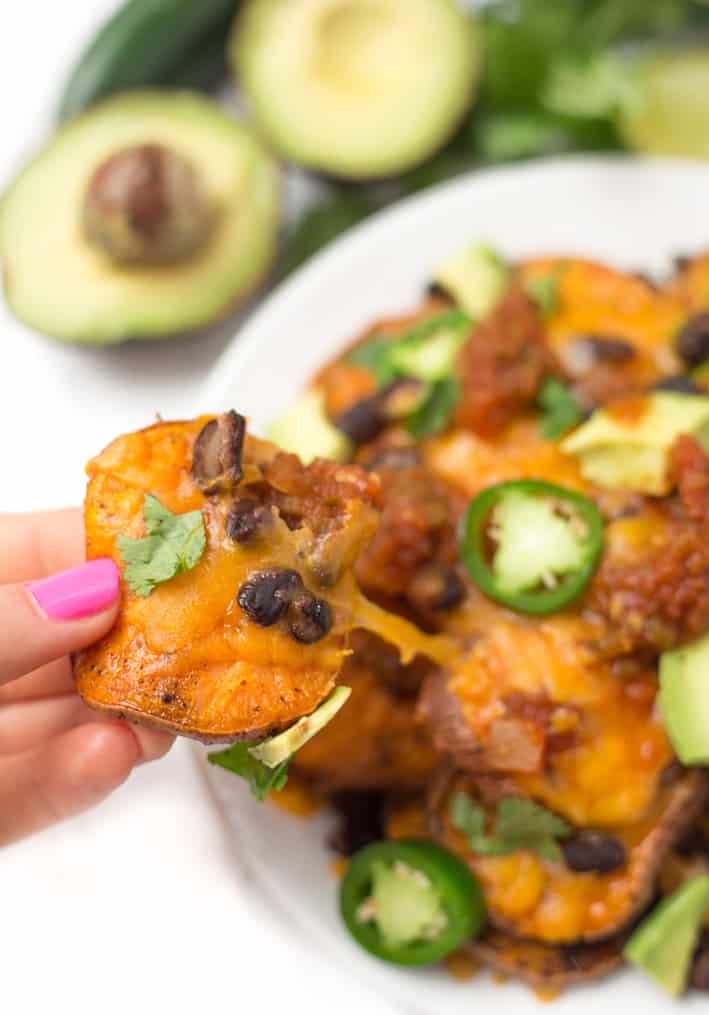 Loaded sweet potato nachos that are even better than traditional nachos! Healthy nachos with sweet potato, avocado, black beans, and melty cheese- what's not to love?!